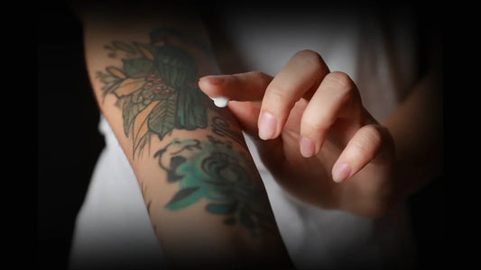 A girl applying cream to her tattoo as part of tattoo aftercare day by day to ensure proper healing and vibrant results.
