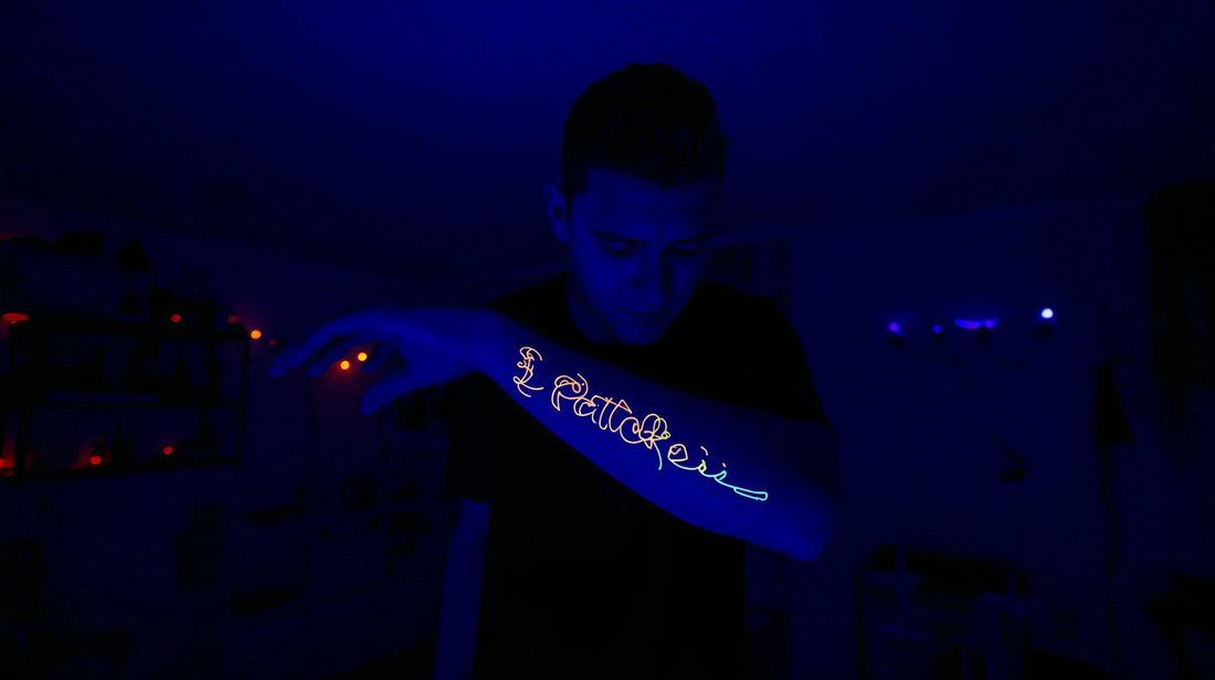 A man showing his UV black light tattoo on his hand